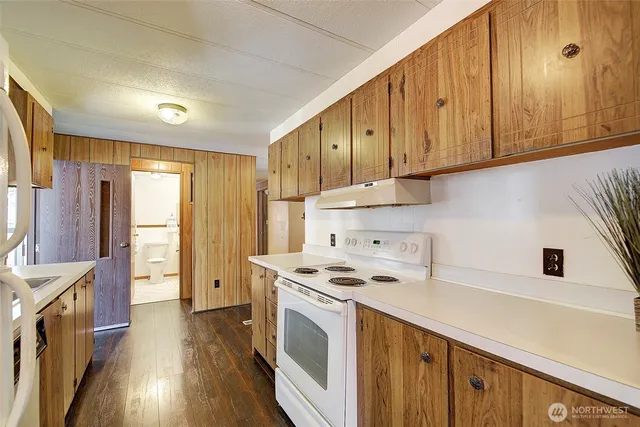 a kitchen with a sink cabinets stainless steel appliances and a window