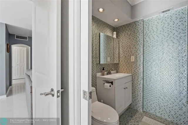 a bathroom with a toilet a sink a mirror and shower