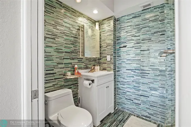 a bathroom with a sink a toilet a mirror and shower