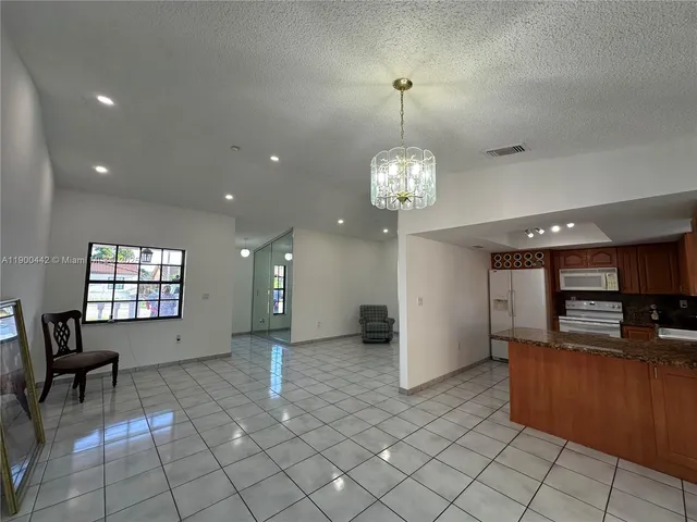 a view of a living room and kitchen with windows