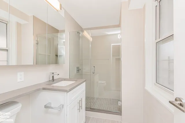 a bathroom with a sink double vanity mirror and a bathtub