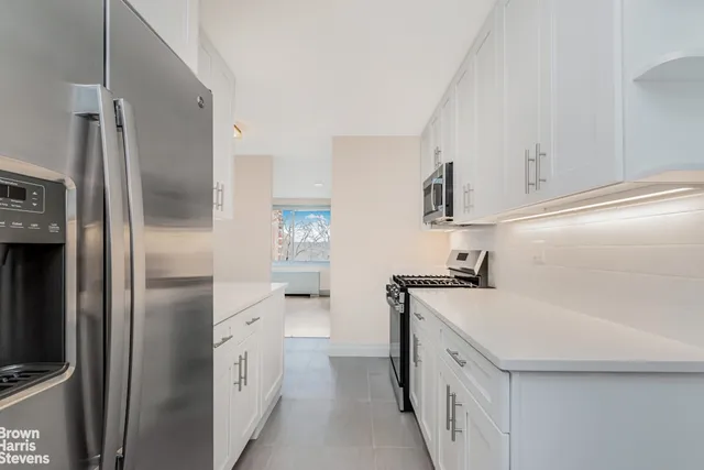 a kitchen with granite countertop white cabinets and stainless steel appliances