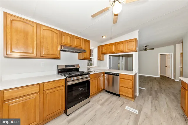 a kitchen with granite countertop wooden floors and stainless steel appliances