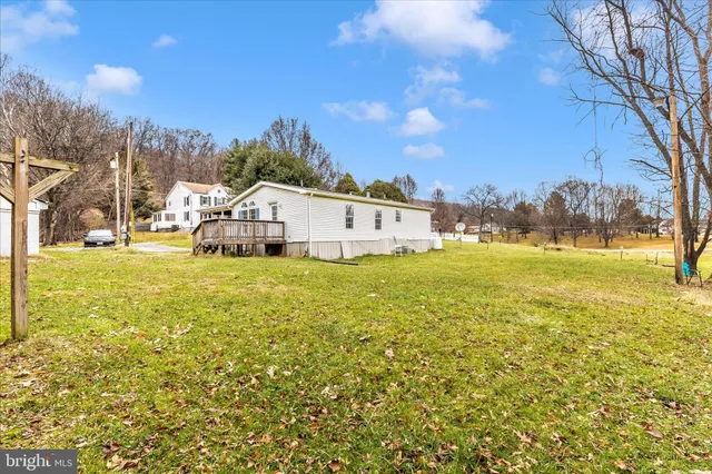 a view of a big yard with table and chairs under an umbrella