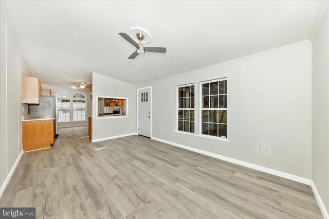 a view of an empty room with a window and wooden floor