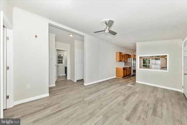 a view of empty room with wooden floor and window