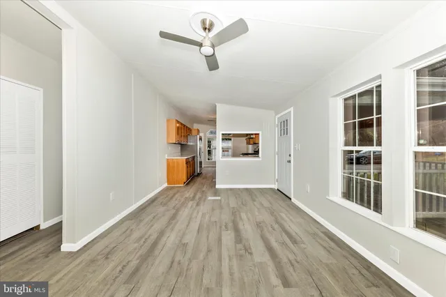 a view of empty room with wooden floor and windows
