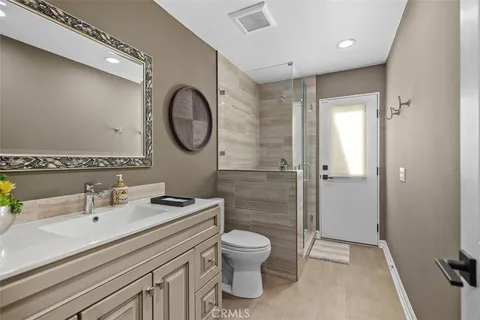 a bathroom with a granite countertop sink toilet a mirror and shower