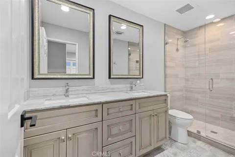 a bathroom with a granite countertop sink a toilet and a mirror