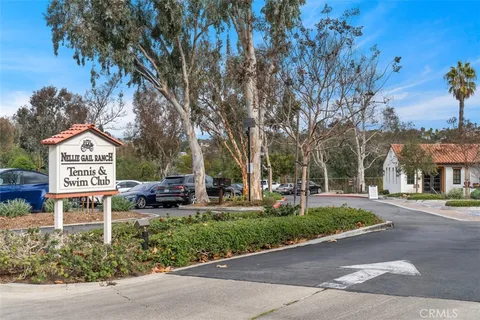 a sign board with a bench and trees around