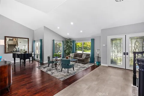 a living room with furniture large window and wooden floor