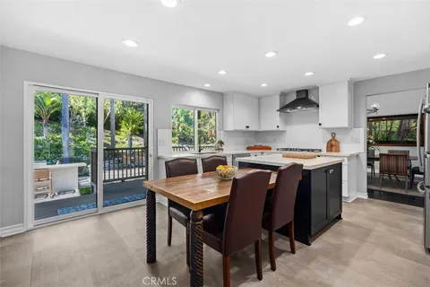 a kitchen with stainless steel appliances granite countertop a stove a sink a microwave a dining table and chairs