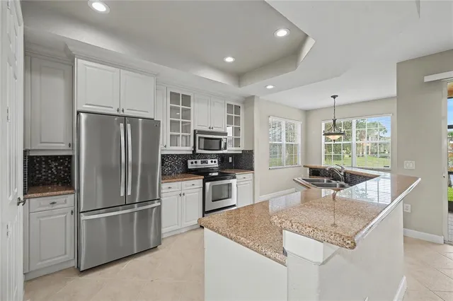 a kitchen with kitchen island a refrigerator stove microwave and cabinets