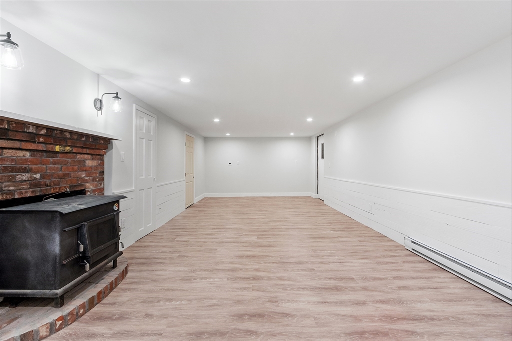 254 Taylor Road Stow, MA 01775 - Photo 39 of 42 a view of empty room with wooden floor and fireplace