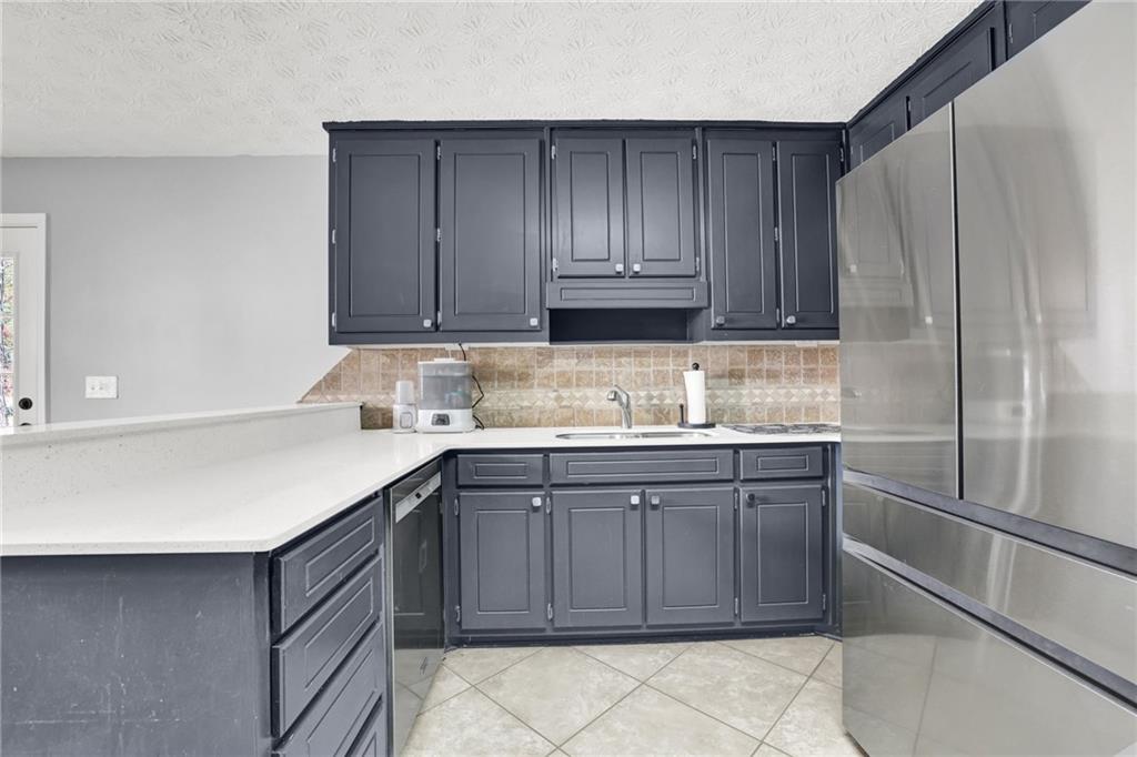 1805 Tribble Ridge Drive Lawrenceville, GA 30045 - Photo 12 of 46 a kitchen with stainless steel appliances granite countertop a sink stove and refrigerator