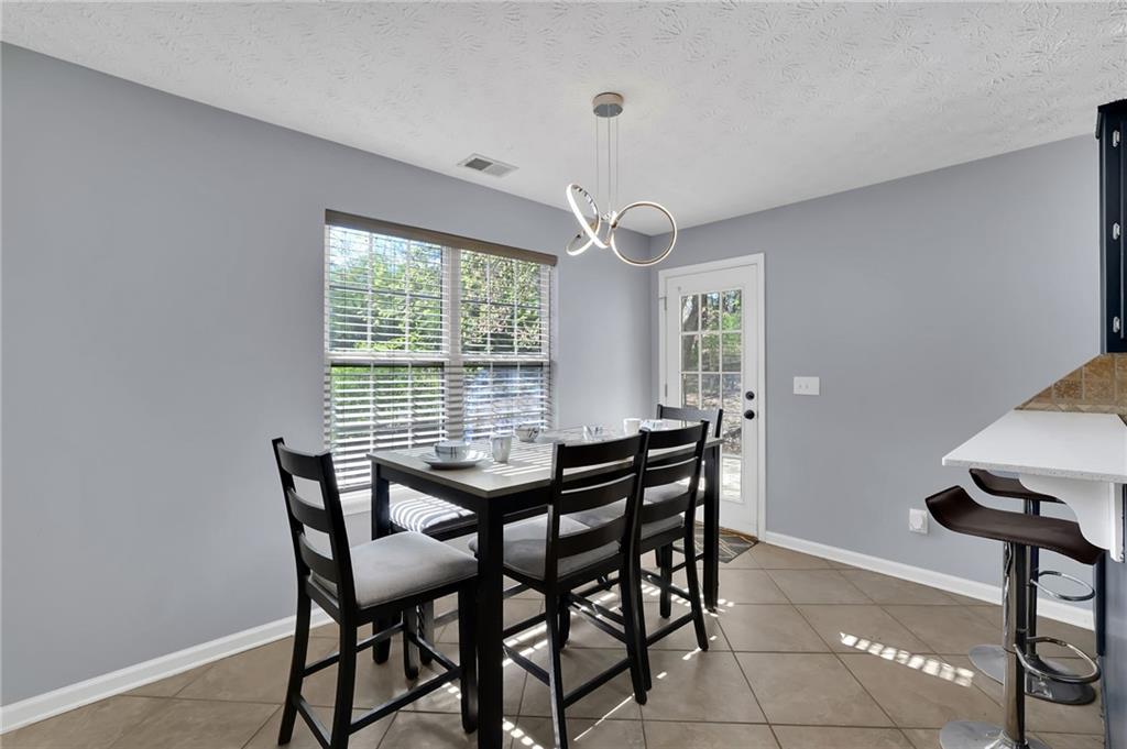 1805 Tribble Ridge Drive Lawrenceville, GA 30045 - Photo 13 of 46 a view of a dining room with furniture and a chandelier