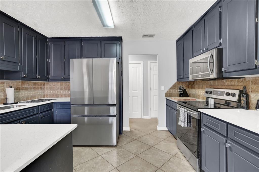 1805 Tribble Ridge Drive Lawrenceville, GA 30045 - Photo 14 of 46 a kitchen with stainless steel appliances granite countertop a refrigerator stove a sink and dishwasher