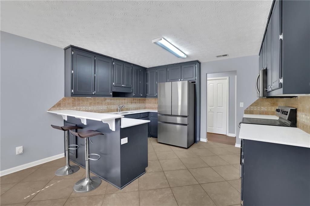 1805 Tribble Ridge Drive Lawrenceville, GA 30045 - Photo 15 of 46 a kitchen with a stove a refrigerator and a sink