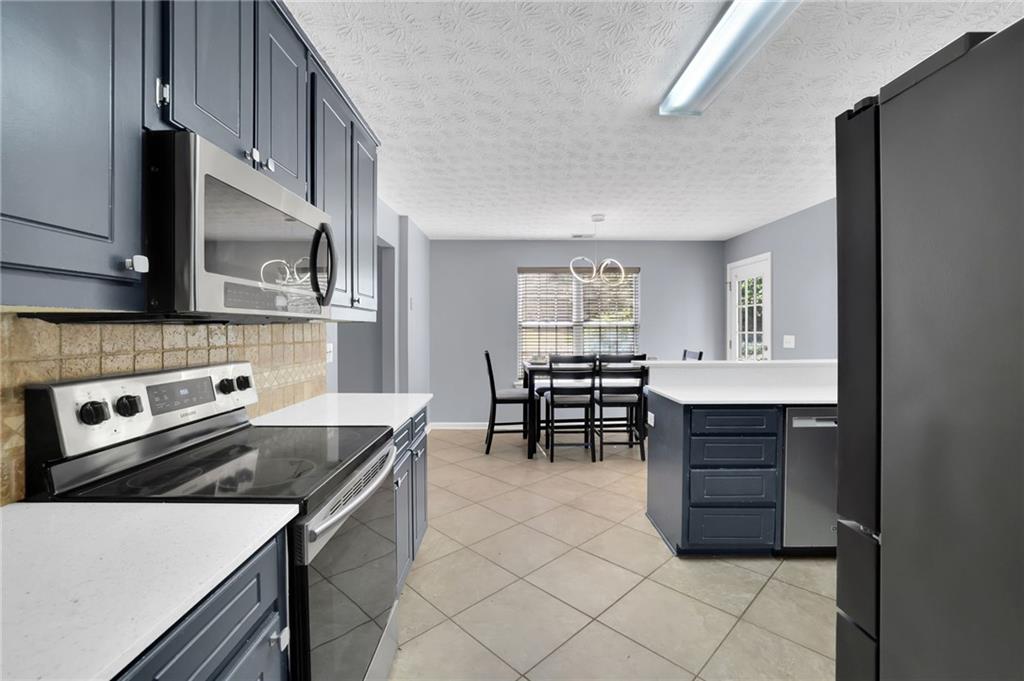 1805 Tribble Ridge Drive Lawrenceville, GA 30045 - Photo 18 of 46 a kitchen with a stove a sink and a microwave