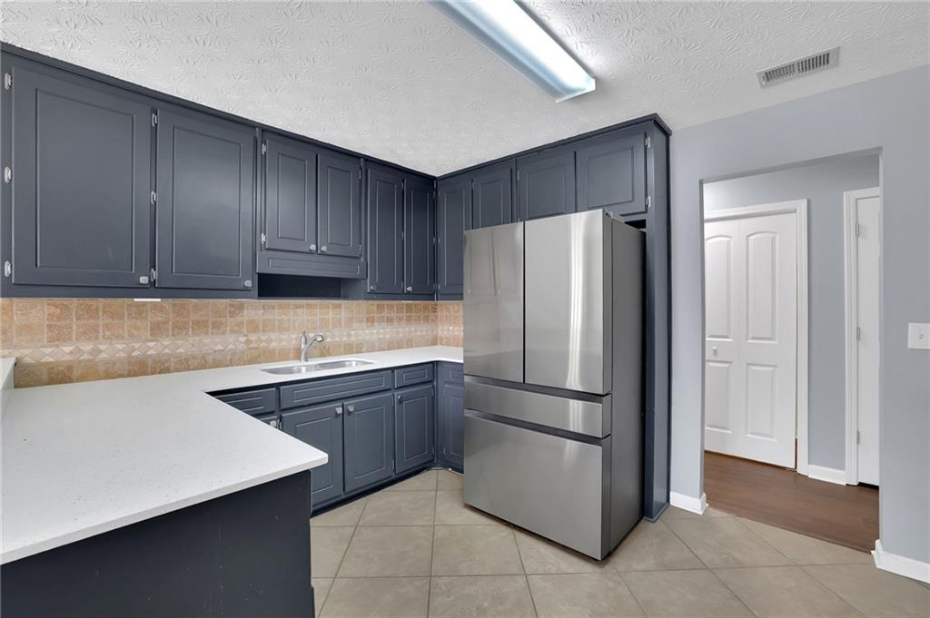 1805 Tribble Ridge Drive Lawrenceville, GA 30045 - Photo 20 of 46 a kitchen with stainless steel appliances cabinets and refrigerator