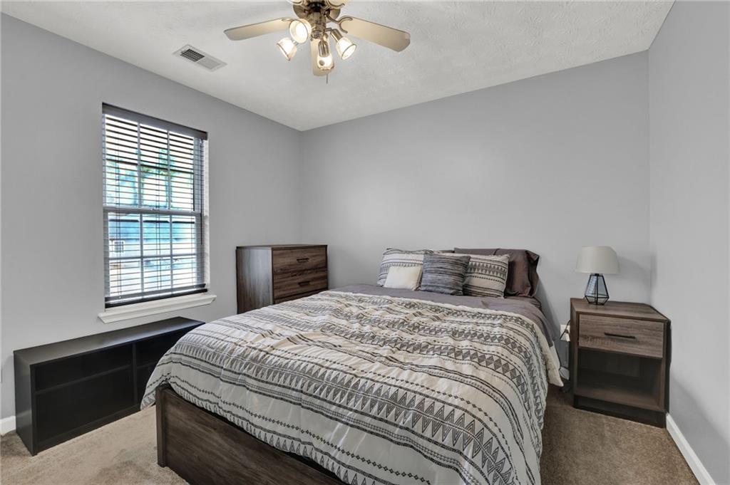 1805 Tribble Ridge Drive Lawrenceville, GA 30045 - Photo 24 of 46 a bedroom with a bed and a chandelier