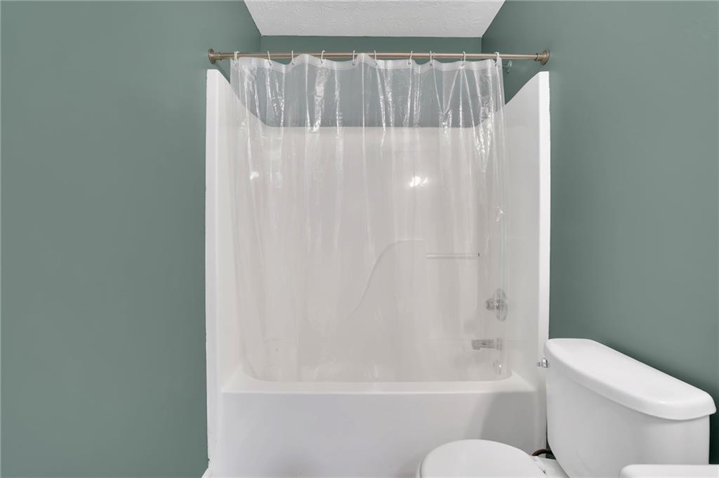 1805 Tribble Ridge Drive Lawrenceville, GA 30045 - Photo 29 of 46 a bathroom with a shower curtain and toilet