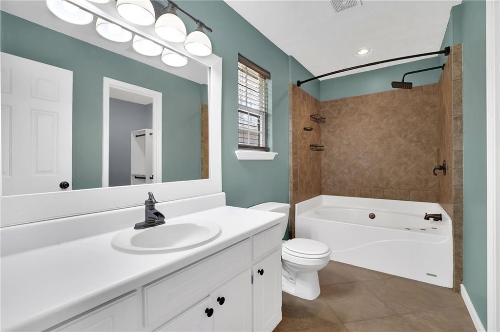 1805 Tribble Ridge Drive Lawrenceville, GA 30045 - Photo 34 of 46 a bathroom with a sink a toilet and a large mirror