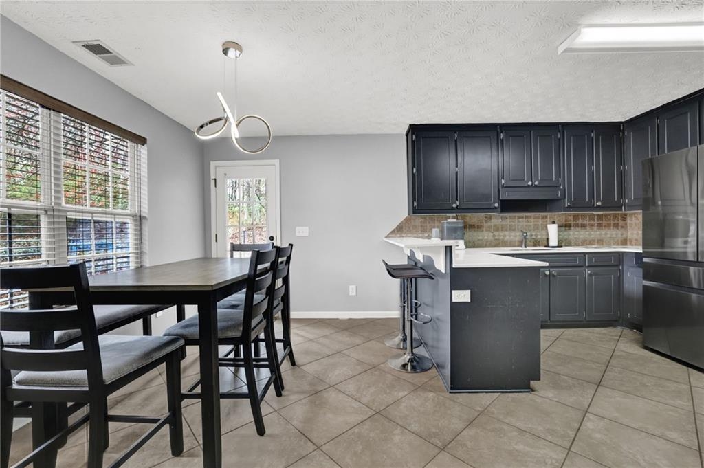 1805 Tribble Ridge Drive Lawrenceville, GA 30045 - Photo 10 of 46 a kitchen with stainless steel appliances granite countertop a table chairs sink and cabinets