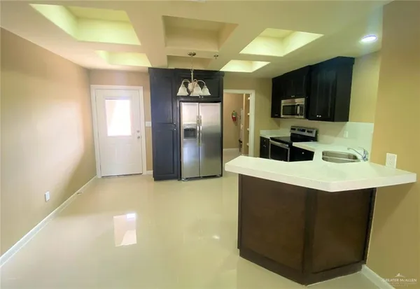 a kitchen with stainless steel appliances a sink a microwave a refrigerator and a stove