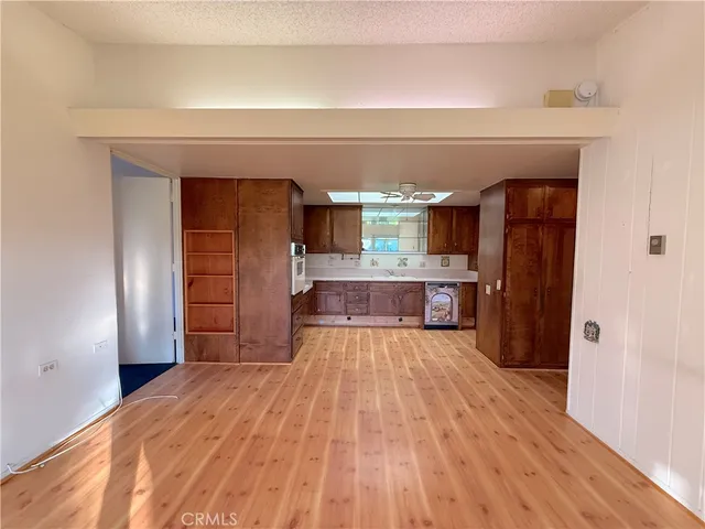 a large kitchen with wooden floor and a refrigerator