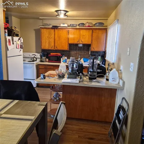 a kitchen with a table chairs and a refrigerator