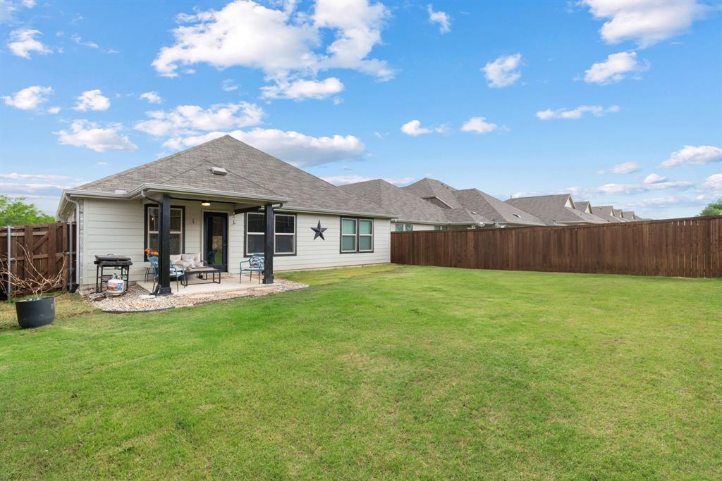 3112 Kingsgarden Road Denton, TX 76207 - Photo 35 of 38 Spacious backyard featuring a large grass lawn, covered patio, and privacy fencing