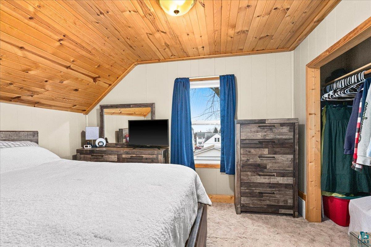 4316 West 6th Street Duluth, MN 55807 - Photo 5 of 39 Bedroom featuring wood ceiling, light colored carpet, wooden walls, and a closet