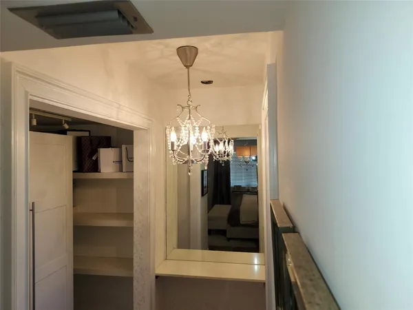 a view of a hallway and a livingroom with furniture