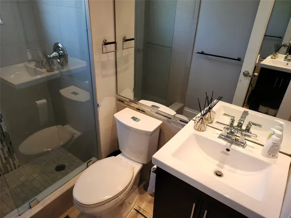 a bathroom with a sink toilet and mirror