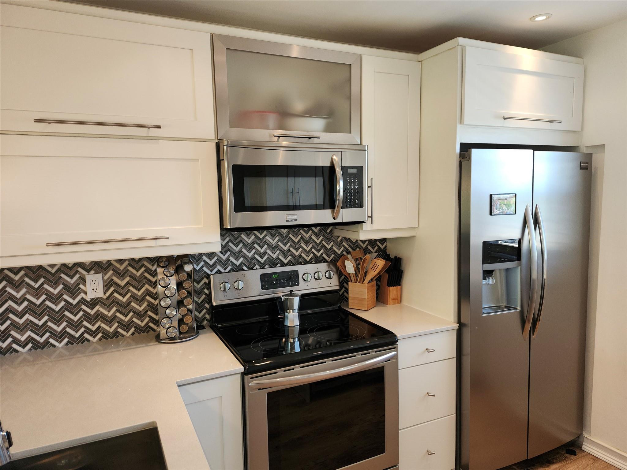 301 Cambridge Road, Unit 301 Hollywood, FL 33024 - Photo 5 of 31 a kitchen with stainless steel appliances granite countertop a refrigerator and a stove top oven