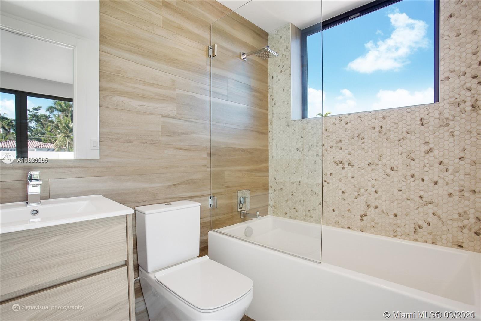 4530 Alton Road Miami Beach, FL 33140 - Photo 16 of 25 a bathroom with a sink a toilet and bathtub