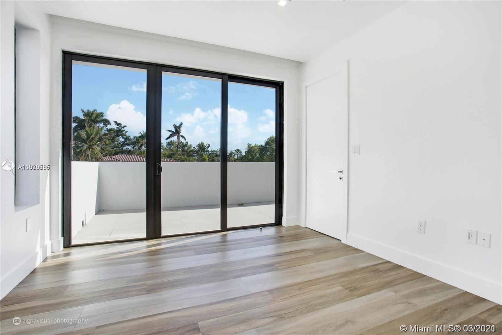 4530 Alton Road Miami Beach, FL 33140 - Photo 17 of 25 an empty room with wooden floor and windows