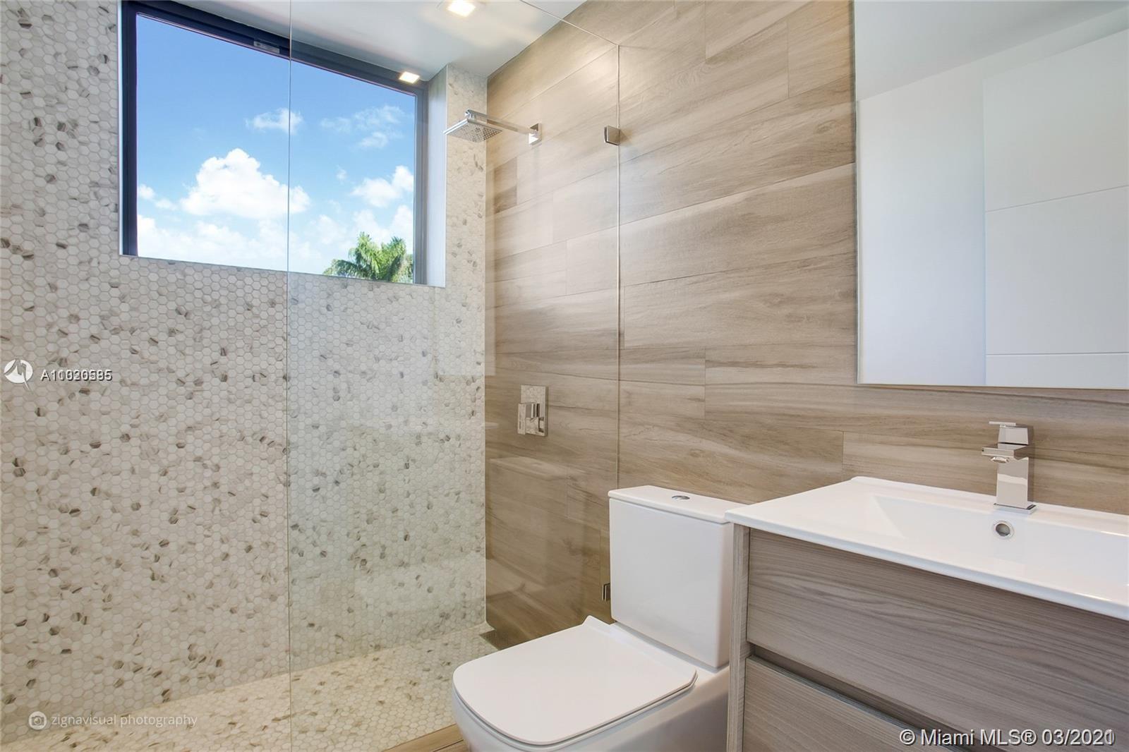 4530 Alton Road Miami Beach, FL 33140 - Photo 18 of 25 a bathroom with a sink a toilet and shower