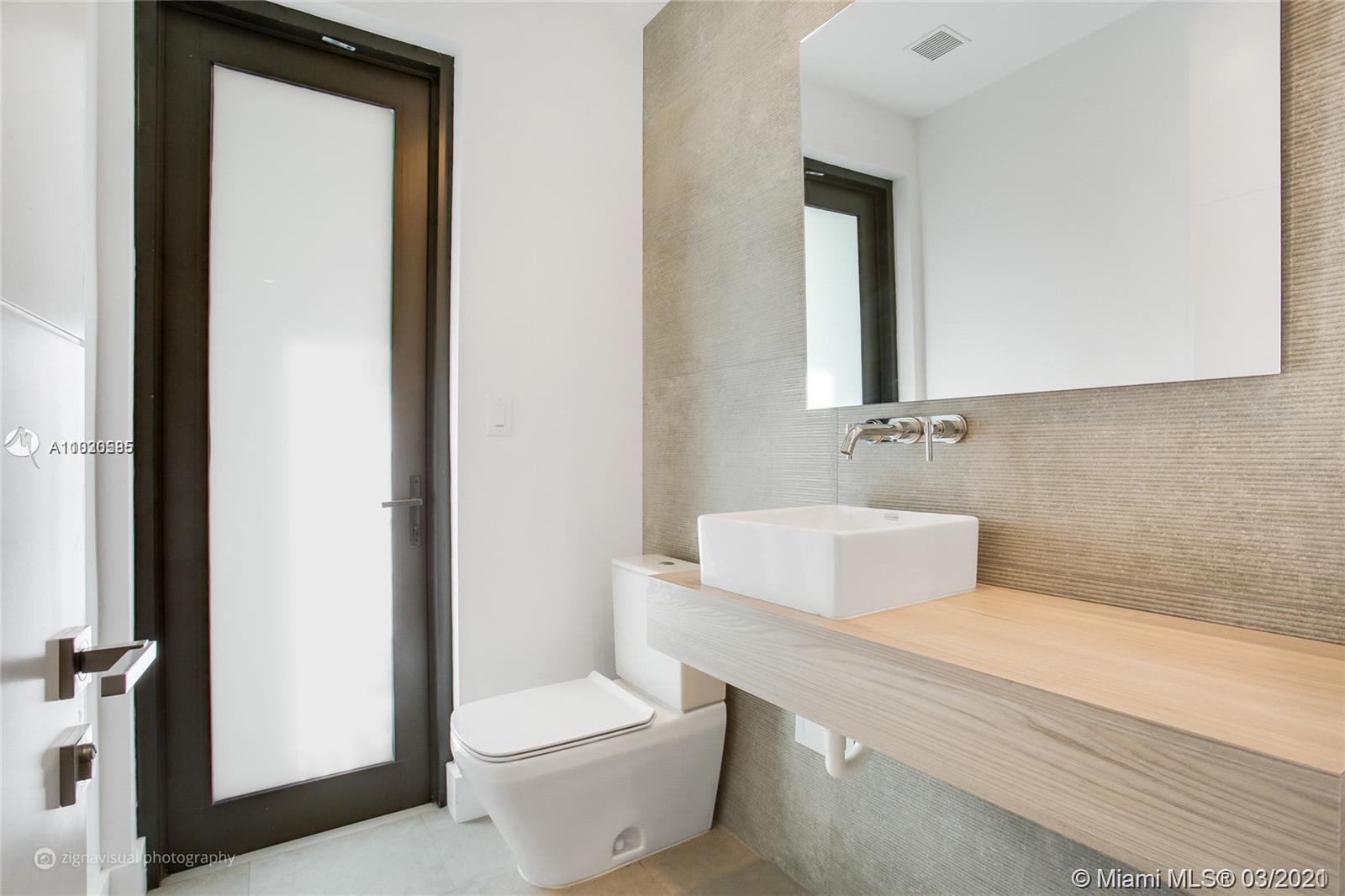 4530 Alton Road Miami Beach, FL 33140 - Photo 24 of 25 a bathroom with a toilet a sink and mirror