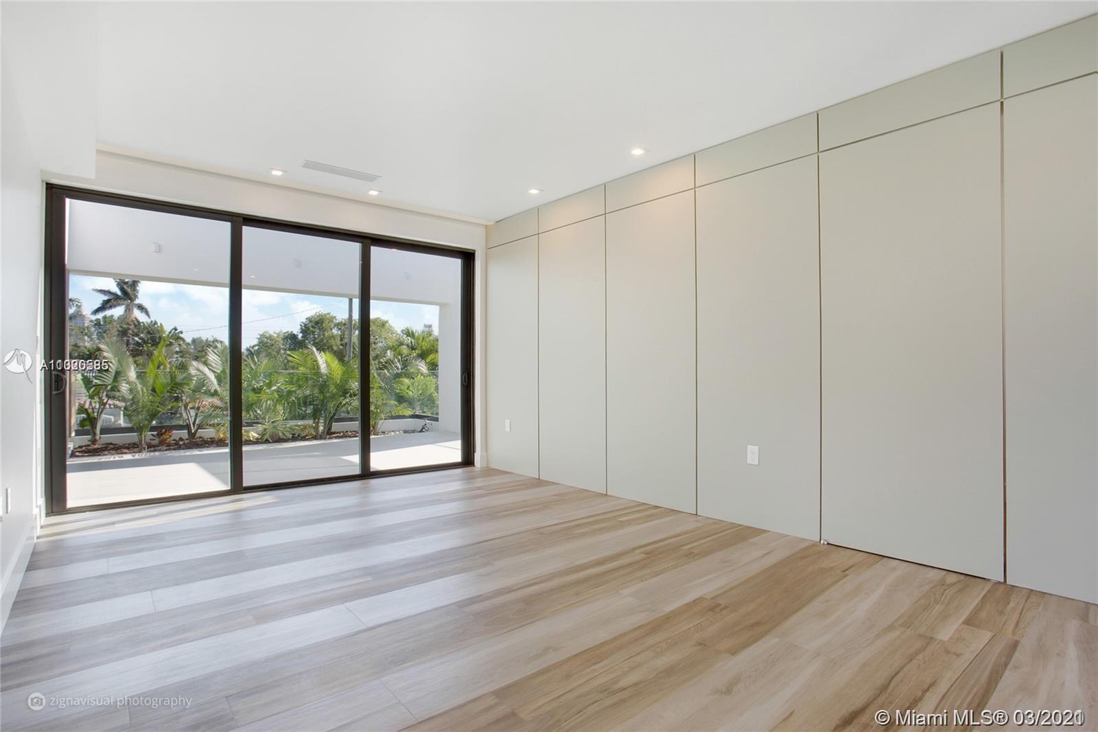 4530 Alton Road Miami Beach, FL 33140 - Photo 5 of 25 a view of an empty room with wooden floor and a window