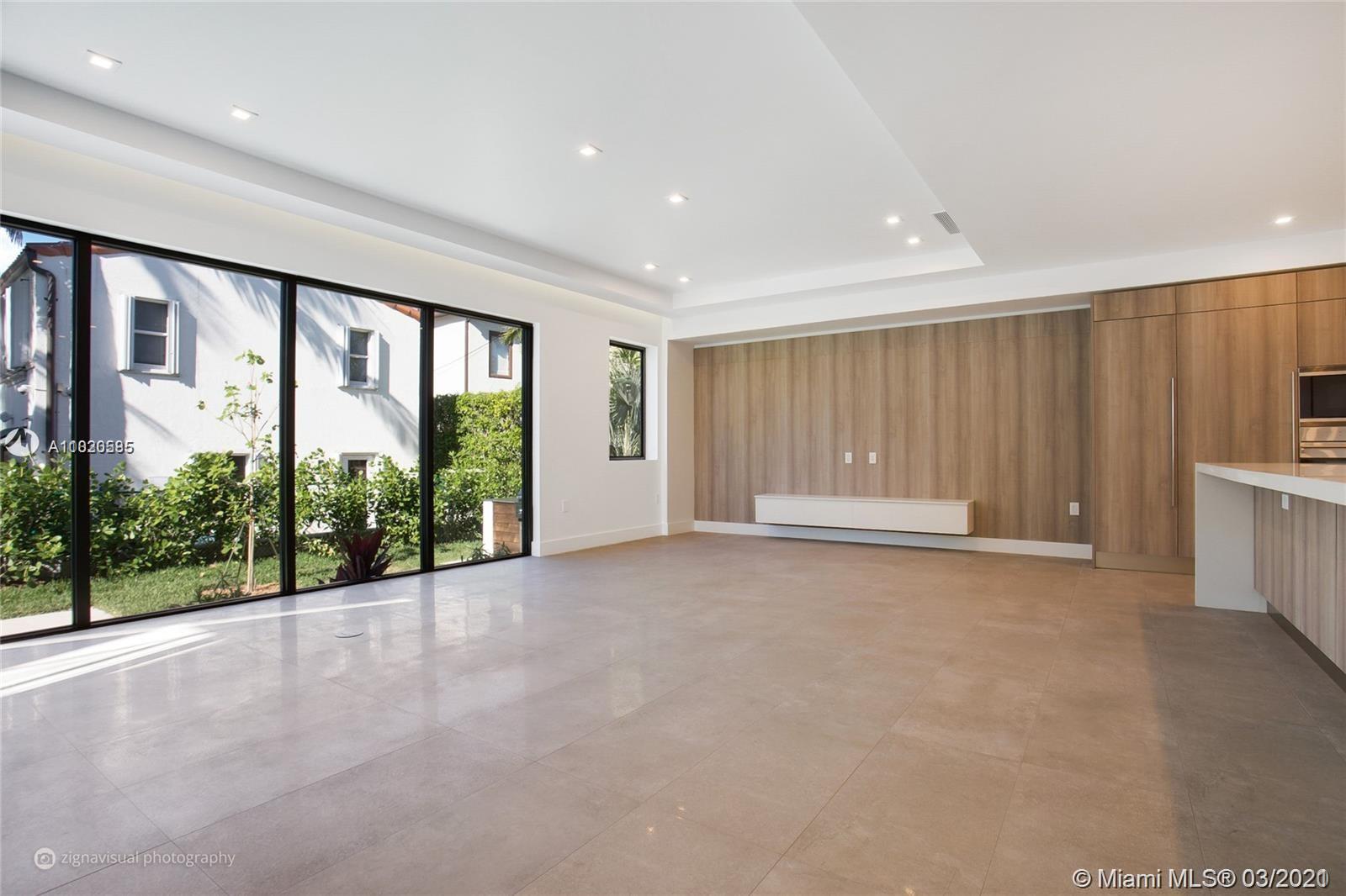 4530 Alton Road Miami Beach, FL 33140 - Photo 7 of 25 a view of an empty room with a sliding door and wooden floor