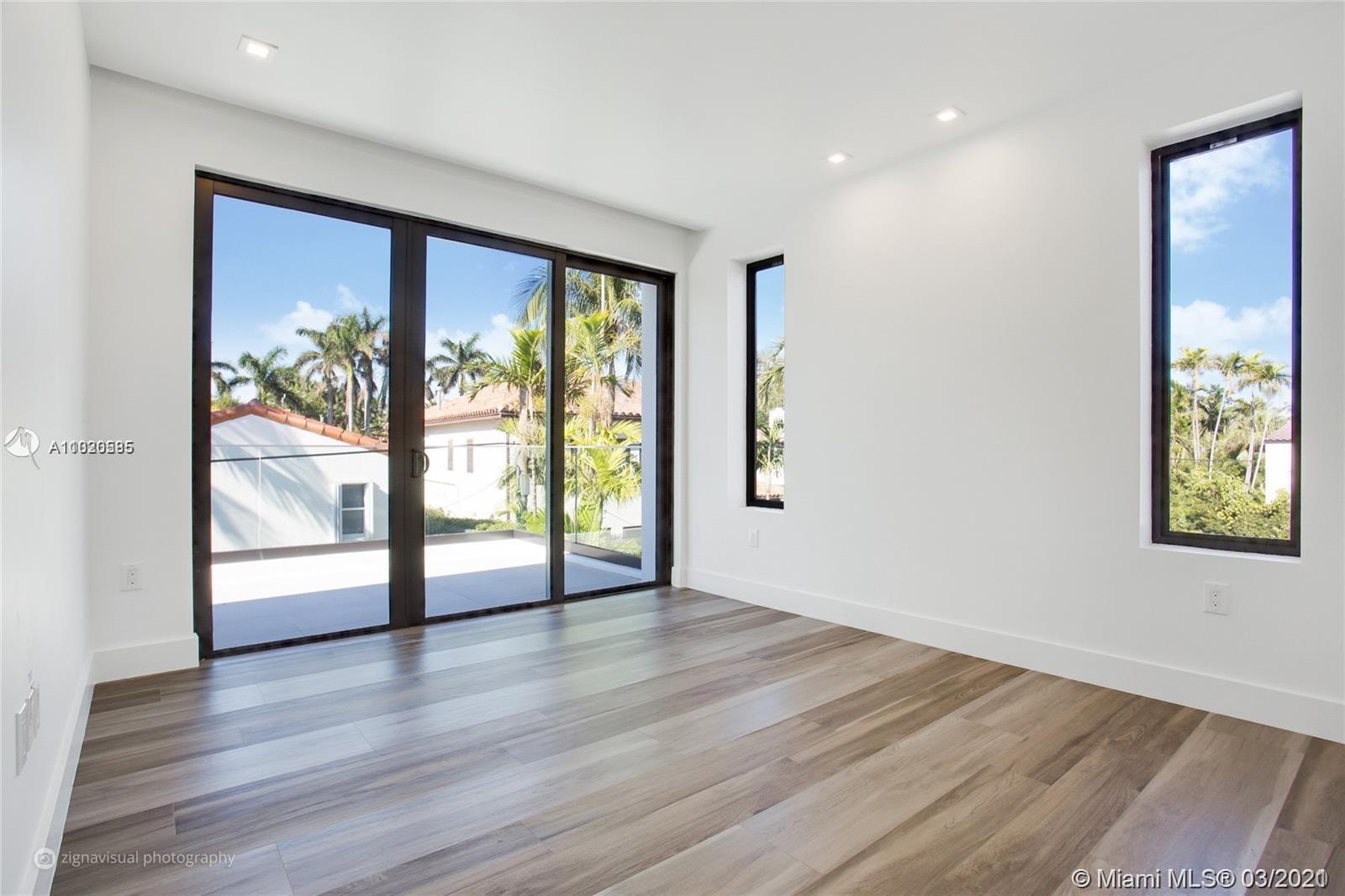 4530 Alton Road Miami Beach, FL 33140 - Photo 9 of 25 an empty room with wooden floor and windows