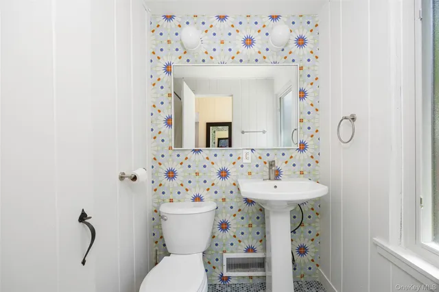 a bathroom with a sink mirror and toilet