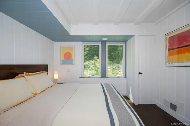 a bedroom with a bed and a painting on the wall