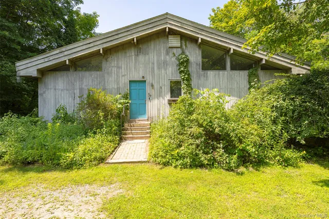 a front view of house with yard and trees around