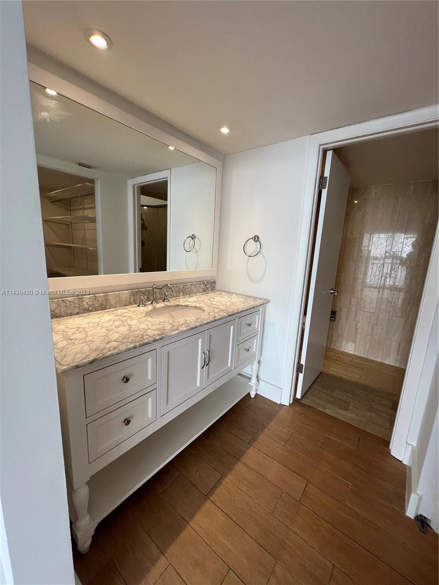 1915 Brickell Avenue, Unit TH16 Miami, FL 33129 - Photo 17 of 36 a spacious bathroom with a granite countertop sink and a mirror