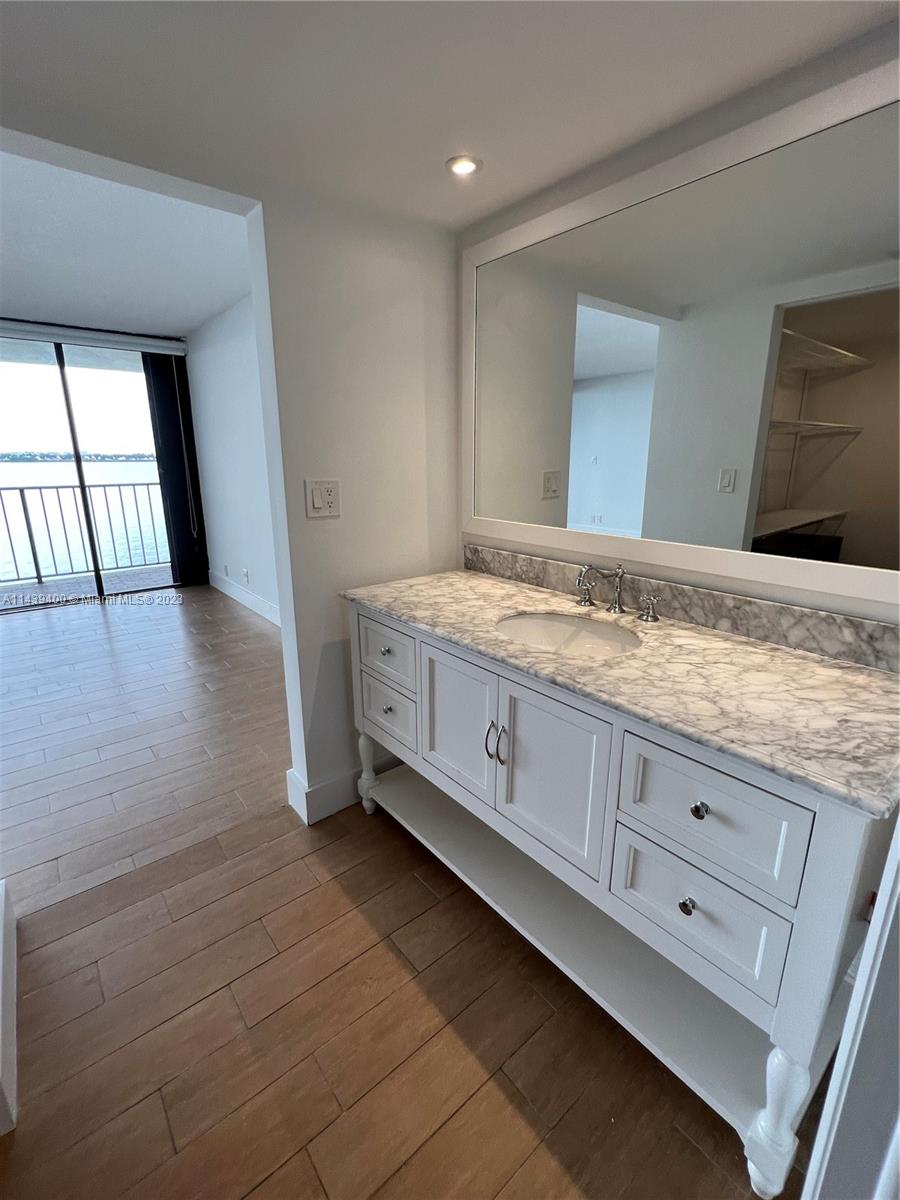 1915 Brickell Avenue, Unit TH16 Miami, FL 33129 - Photo 18 of 36 a bathroom with a granite countertop sink and a vanity