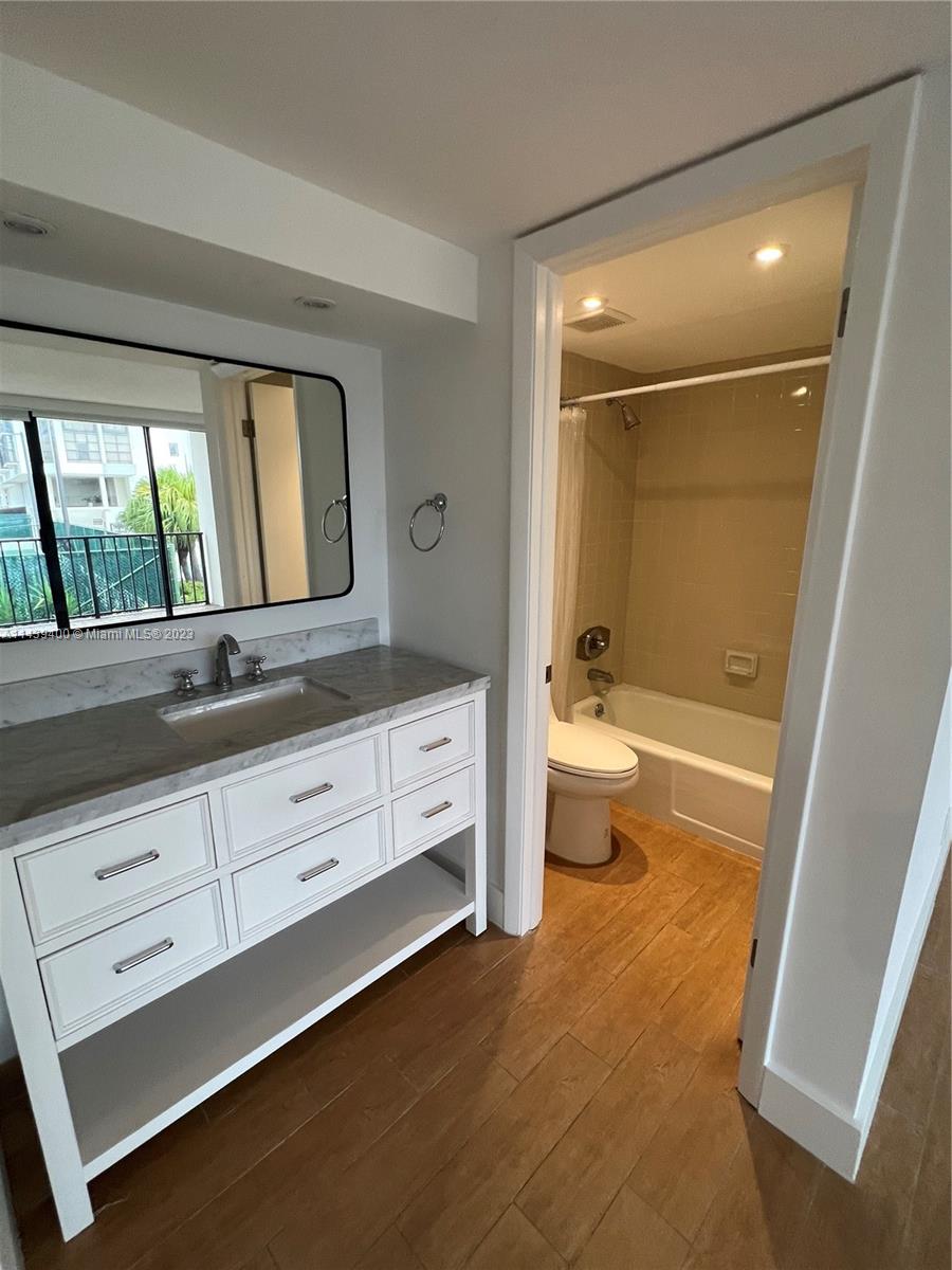 1915 Brickell Avenue, Unit TH16 Miami, FL 33129 - Photo 29 of 36 a bathroom with a double vanity sink toilet mirror and bathtub