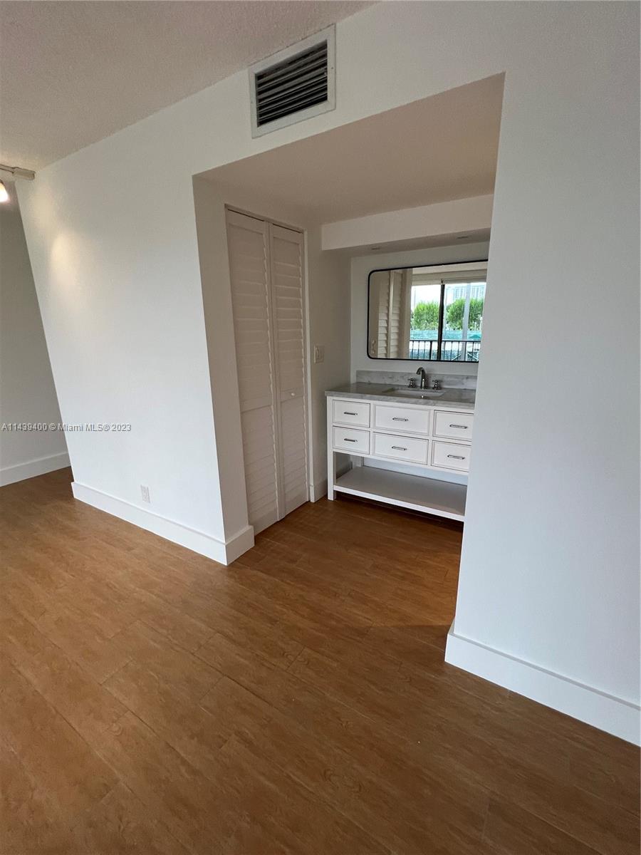 1915 Brickell Avenue, Unit TH16 Miami, FL 33129 - Photo 30 of 36 an empty room with wooden floor cabinet and windows